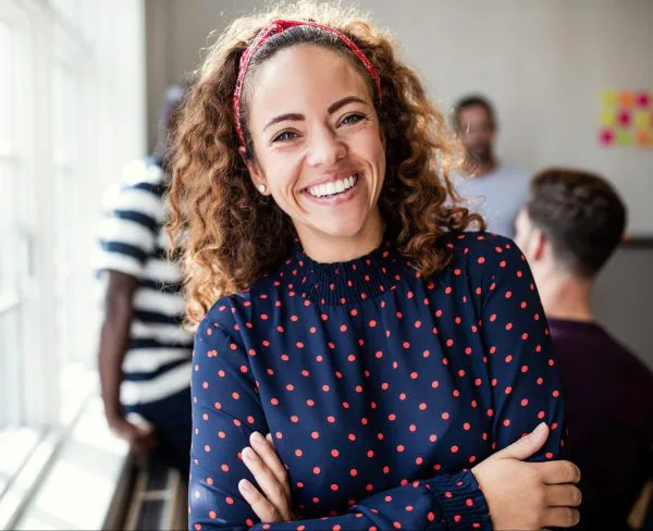 Smiling Woman with Curly Hair Crossing Arms and Smiling