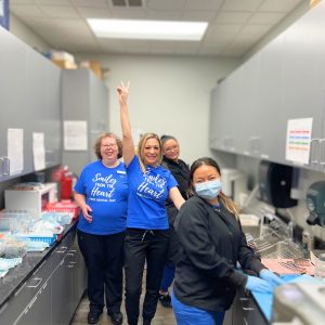 Contemporary family dental team posing in blue smiles from the heart free dental day t-shirts