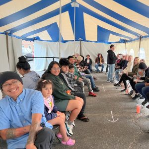 Smiles from the Heart Free Dental Day in Grand Rapids smiling patients under blue and white striped tent